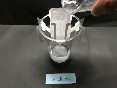 漉し器に水道水を注ぎ汚れを取っている画像